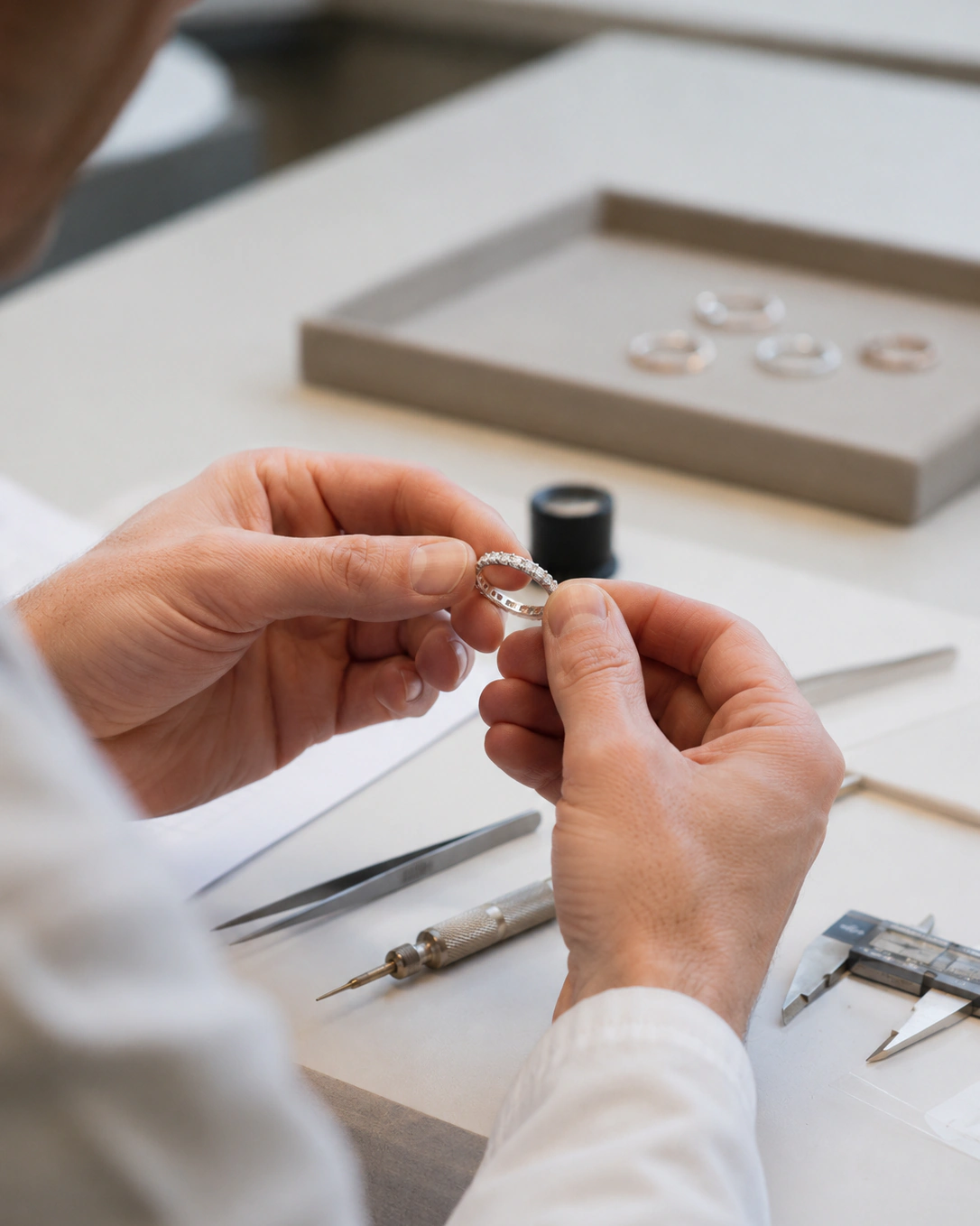 Jeweler inspecting a finished diamond ring during quality control