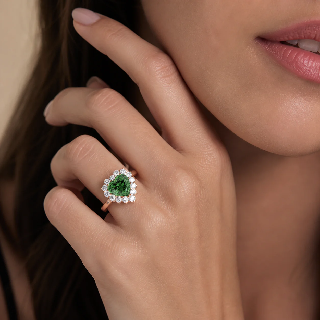 Heart-shaped green centre stone ring framed by a luminous halo on the hand