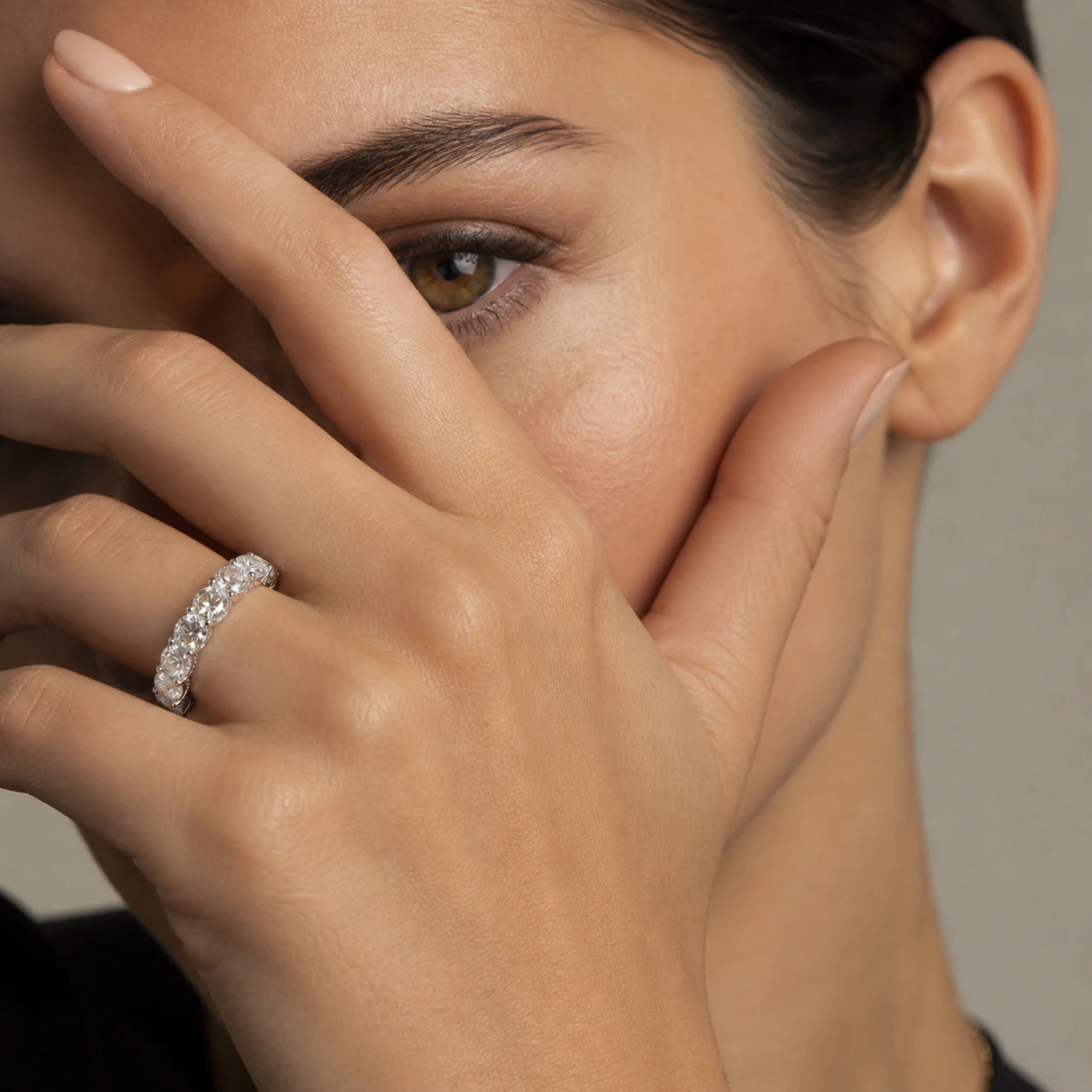 Diamond essential ring seen softly through light and texture on the hand